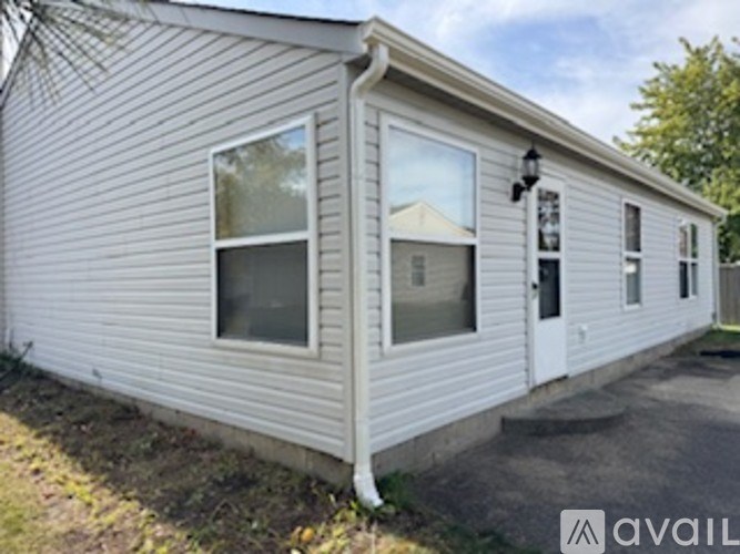 A house with a white door and windows is available for rent.