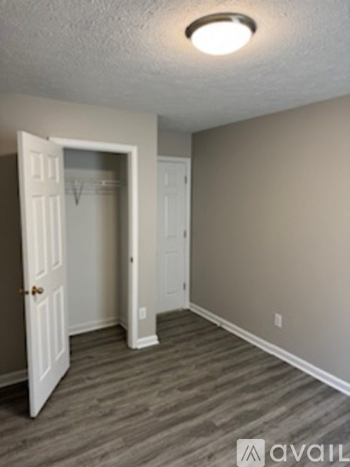 A room with a white door and a wooden floor.