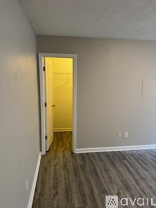 A room with a door and a wooden floor.