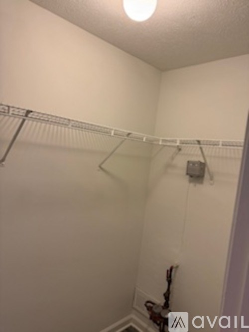A white closet with a hanger on the rod.