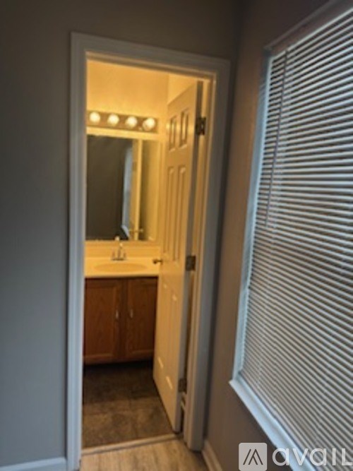 A bathroom with a mirror and lights on the door.
