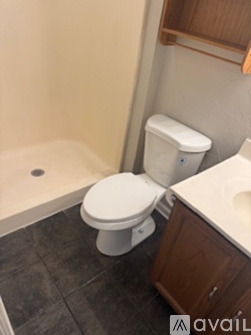 A white toilet sits in a bathroom next to a sink.
