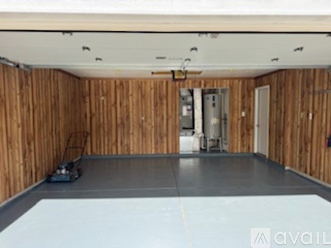A room with wooden walls and a grey floor.