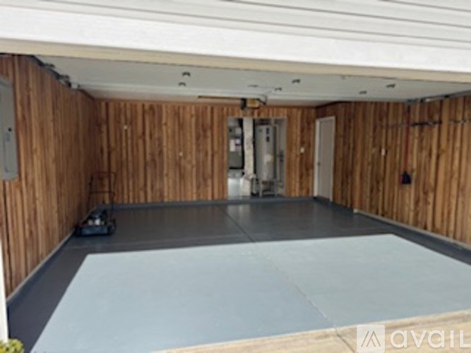 A room with wooden walls and a grey floor.