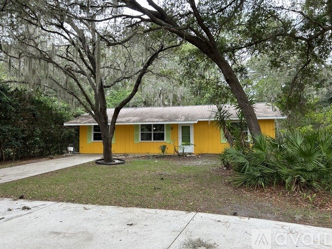 A yellow house with a tree in front of it.