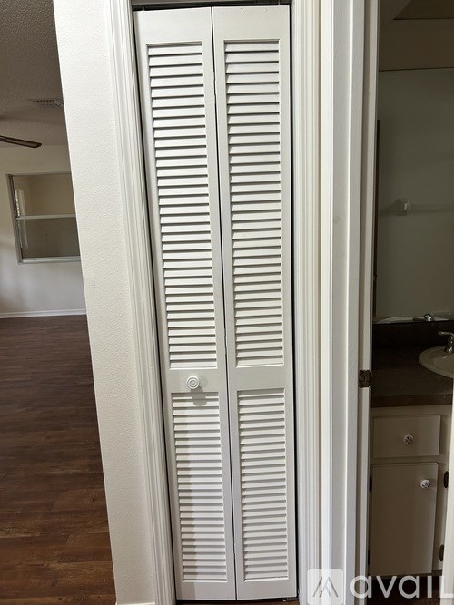 A tall white closet with a mirrored door is open.