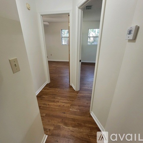 A hallway with wood floors and white walls.
