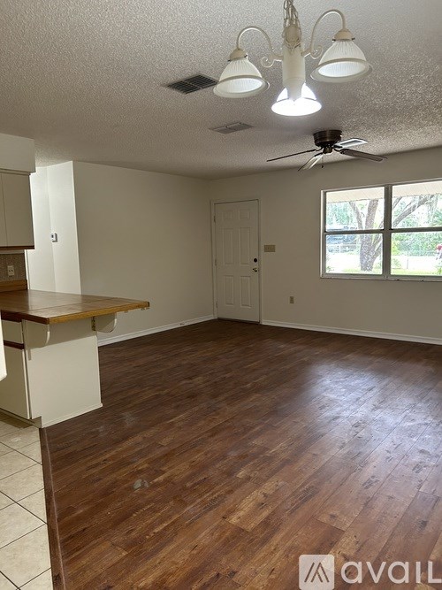 A room with wooden floors and a ceiling fan.