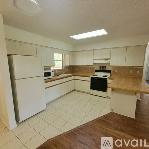 A kitchen with white appliances and wooden countertops.