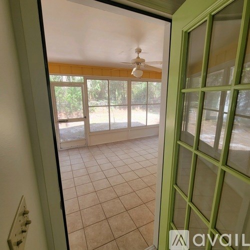 A room with a ceiling fan and tiled floor.