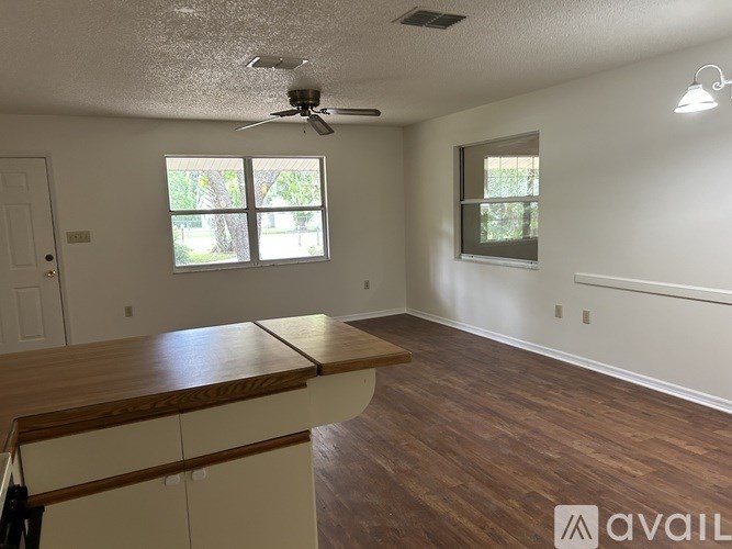 A room with a wooden floor and a ceiling fan.