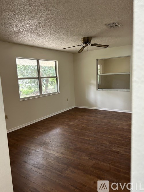 A room with wooden flooring and a ceiling fan.