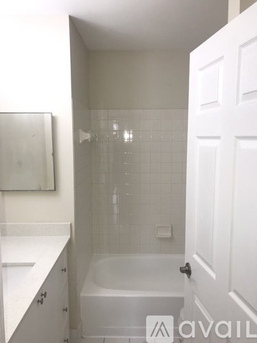 A white bathroom with a tub and a toilet.