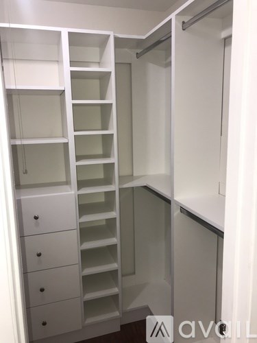 A white walk-in closet with shelves and drawers.