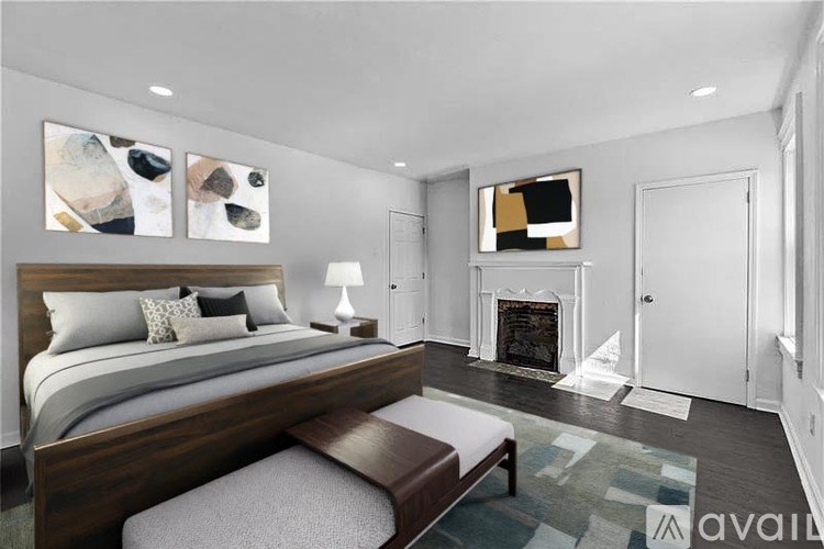 A bedroom with a large bed and a fireplace.