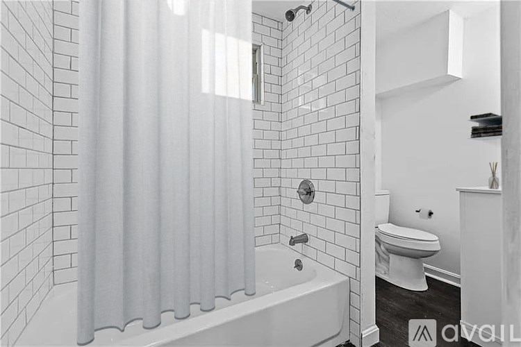 A white bathroom with a tub, toilet and sink.