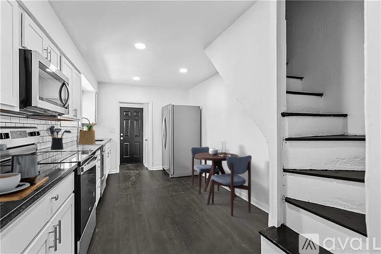 A kitchen with a dining table and chairs in the middle of the room.