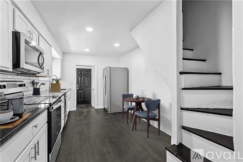 A kitchen with a dining table and chairs in the middle of the room.