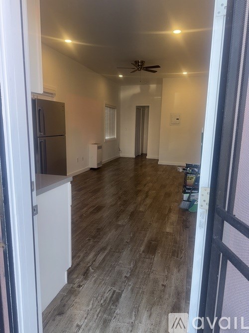 A room with a ceiling fan and wooden flooring.