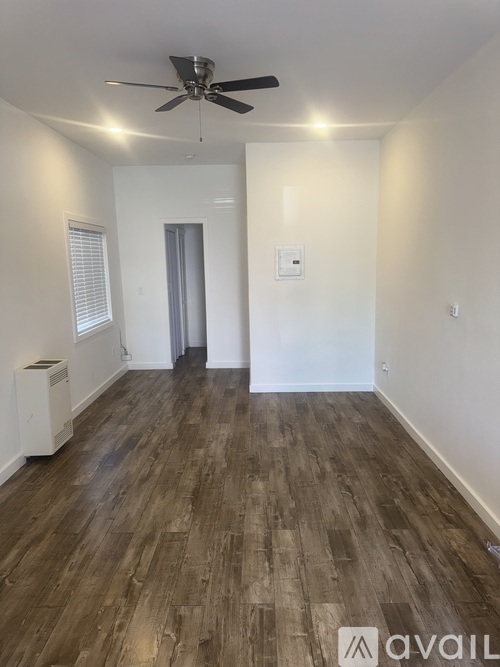 A room with wooden flooring and a ceiling fan.