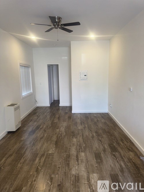 A room with wooden flooring and a ceiling fan.