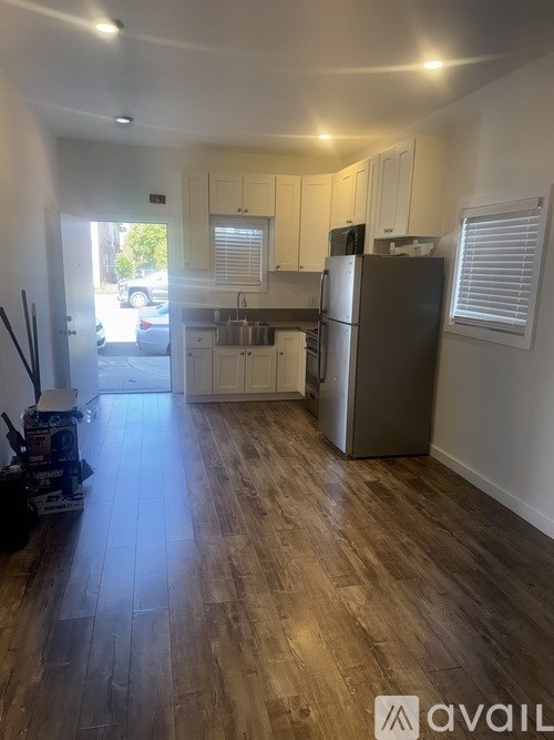 A kitchen with wooden floors and white cabinets.