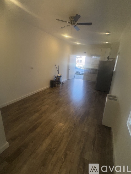 A room with wooden floors and a ceiling fan.