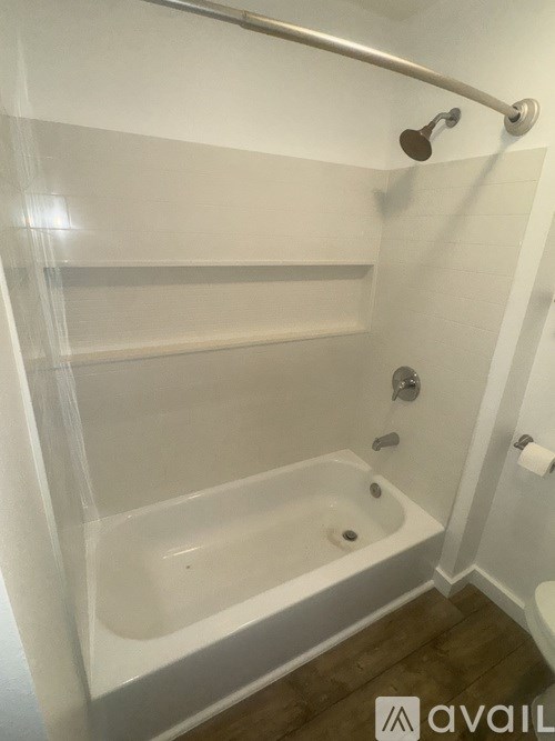 A white bathroom with a glass shower door and a white tub.