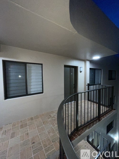 A balcony with a metal railing and a tiled floor.