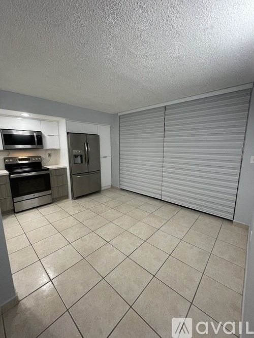 A kitchen with a refrigerator, oven, and microwave.