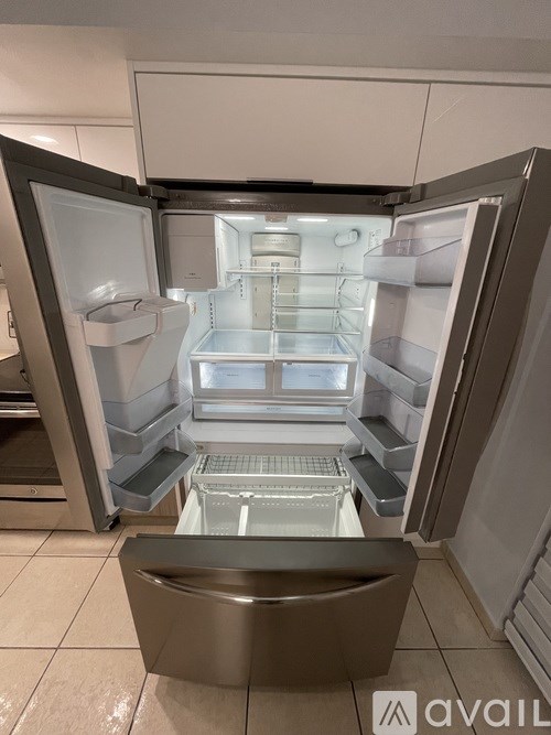 A large, empty, stainless steel refrigerator with its door open.