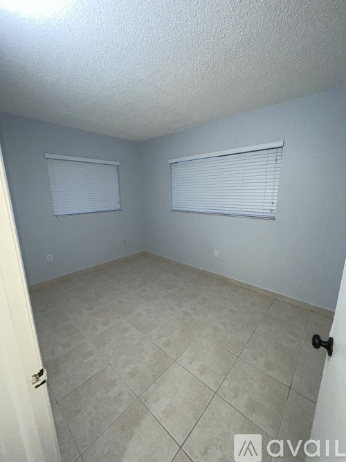 A room with tiled flooring and a door on the left.