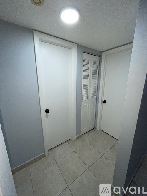 A hallway with two doors and a tiled floor.