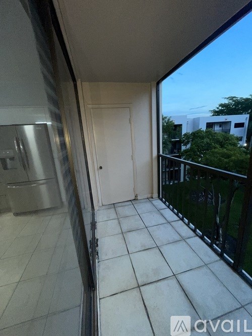 A balcony with a glass railing and a white door.