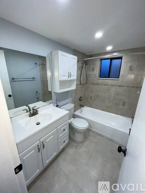 A bathroom with a white sink, toilet, and bathtub.
