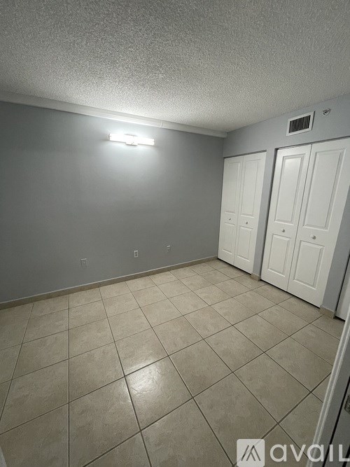 A room with tile flooring and white doors.