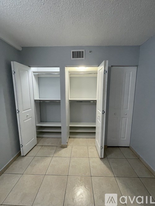 A room with a tiled floor and two open doors.