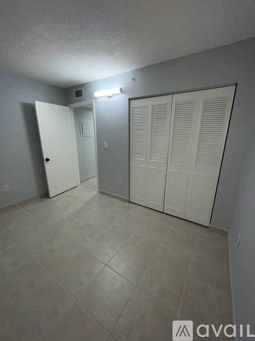 A room with a white door and a white cabinet with a light on.