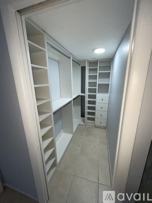A white hallway with a staircase and drawers.