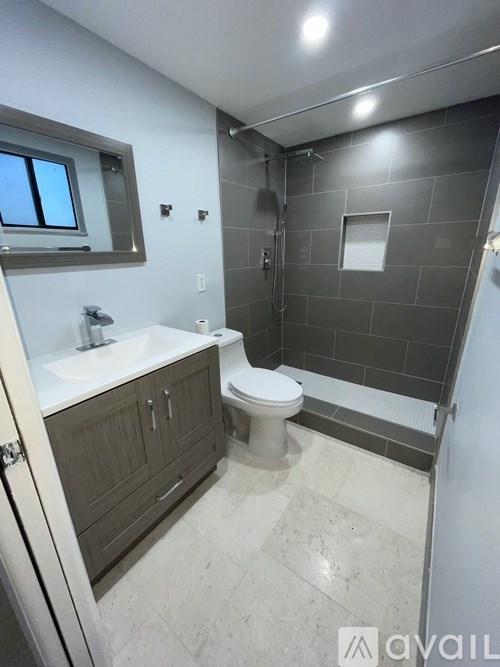 A bathroom with a toilet, sink, and shower.