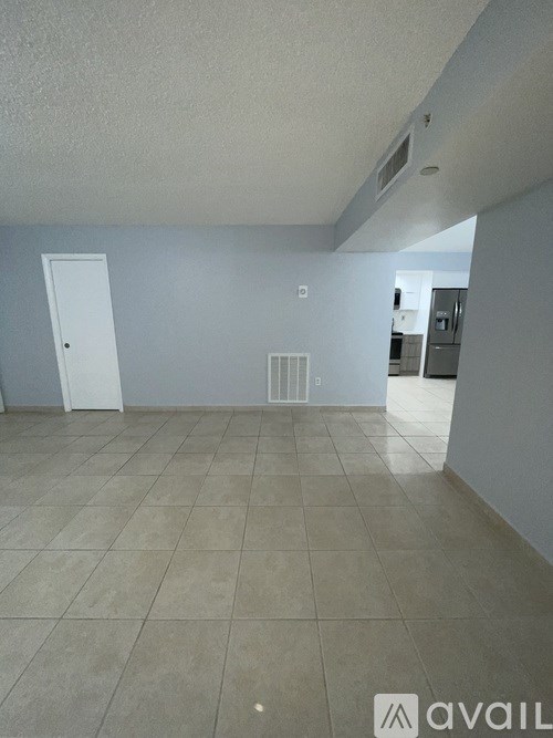 A room with a tiled floor and a white door.
