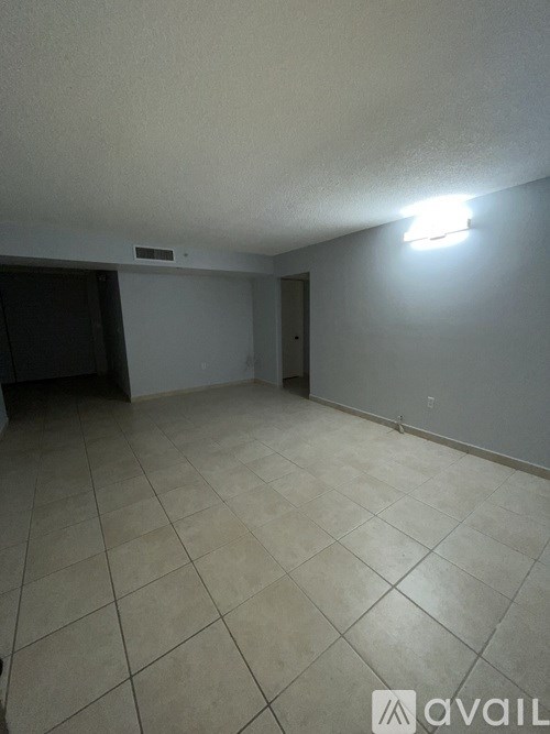 A room with a tiled floor and a light on the wall.