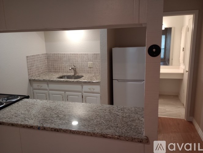A kitchen with granite countertops and a white fridge.