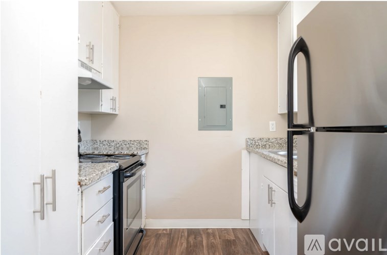 A kitchen with white cabinets and a stainless steel refrigerator.