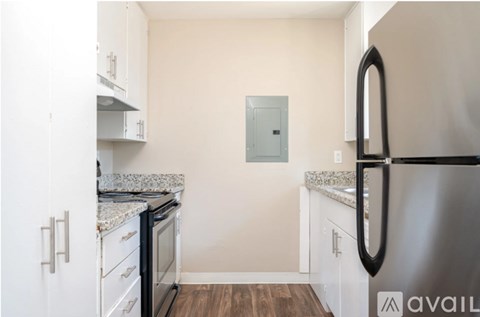A kitchen with white cabinets and a stainless steel refrigerator.