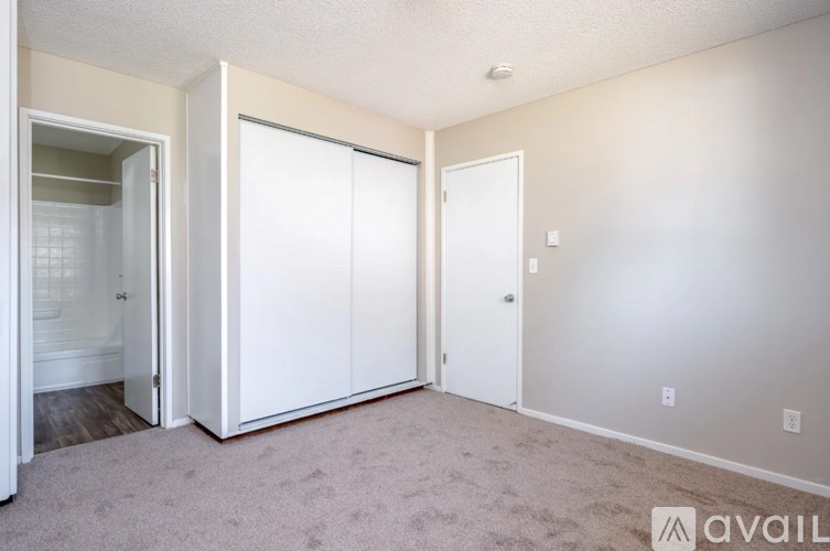 A room with a carpeted floor and a white door.