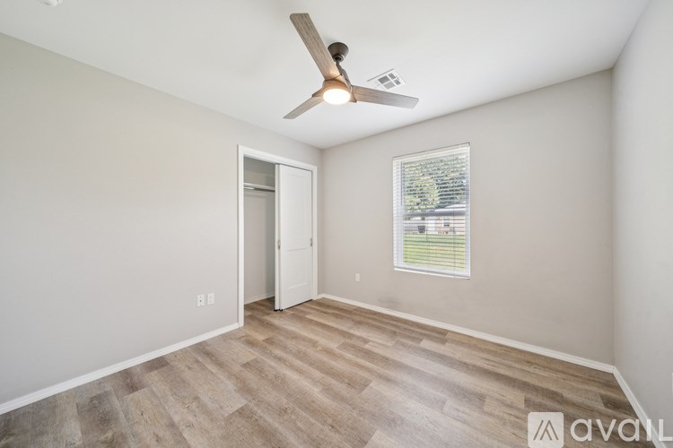 A room with a ceiling fan and a window with blinds.
