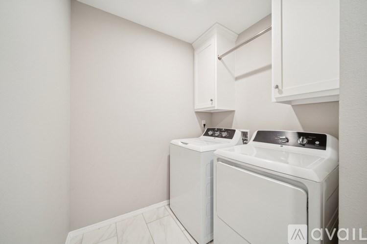 A white washing machine and dryer in a small laundry room.