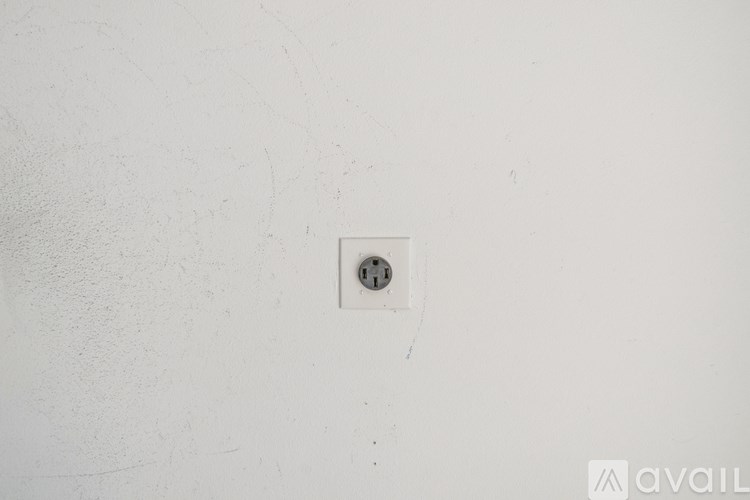 A white wall with a switch and a socket.