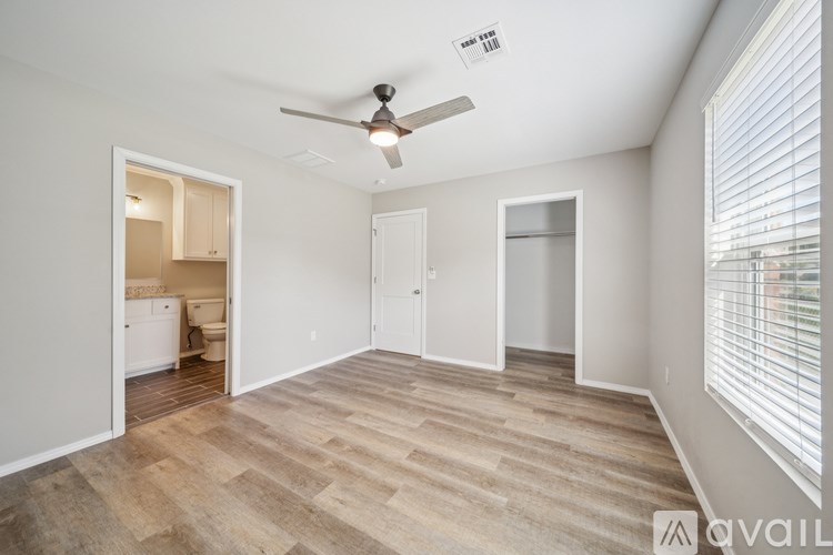 A room with a ceiling fan and light fixture, and a window with blinds.